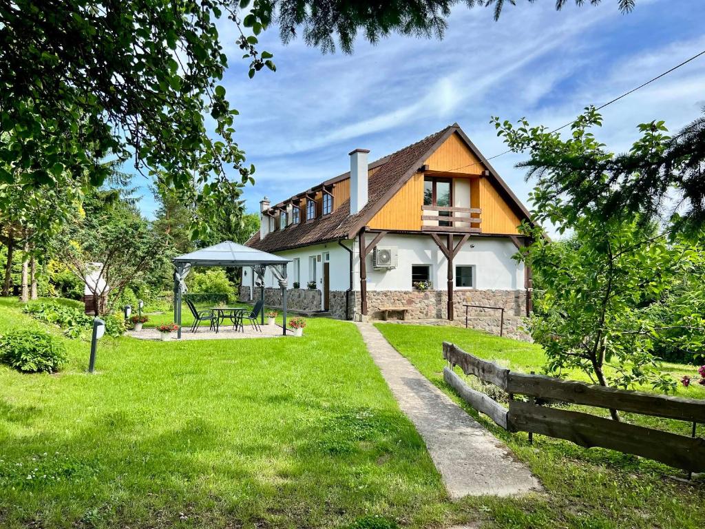 a house with a fence and a grass yard at Apartament Pod Wiatrakiem in Bęsia