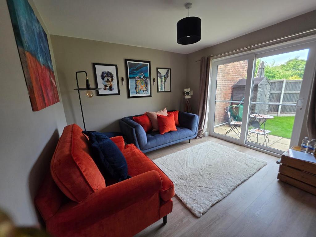 a living room with two couches and a large window at Olive & Ember - 1 Bed with private garden in Hythe