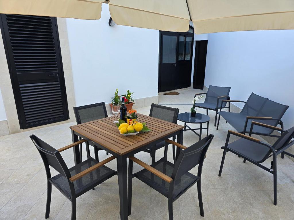 a table and chairs with a bowl of fruit on it at Lemon House in Avola