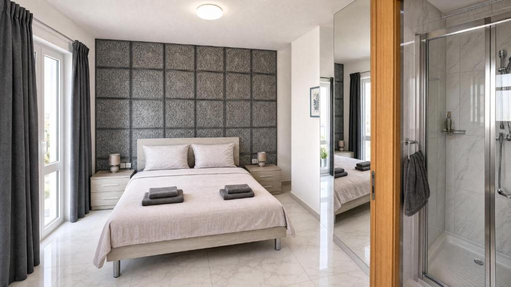 a bedroom with a large bed and a walk in shower at Arzella Apartments Xlendi, Premium 2BR, Bus Stop & Market Opposite in Xlendi