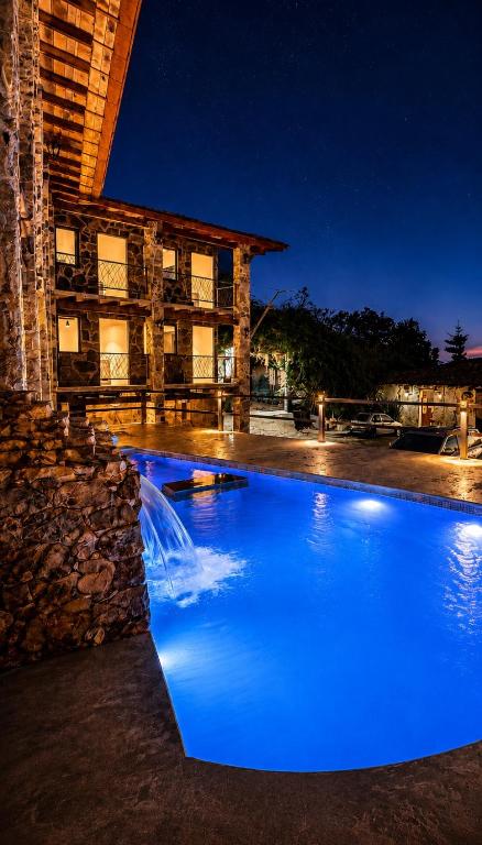a blue pool in front of a building at night at La Peña Hotel Boutique & SPA in Cuetzalán del Progreso
