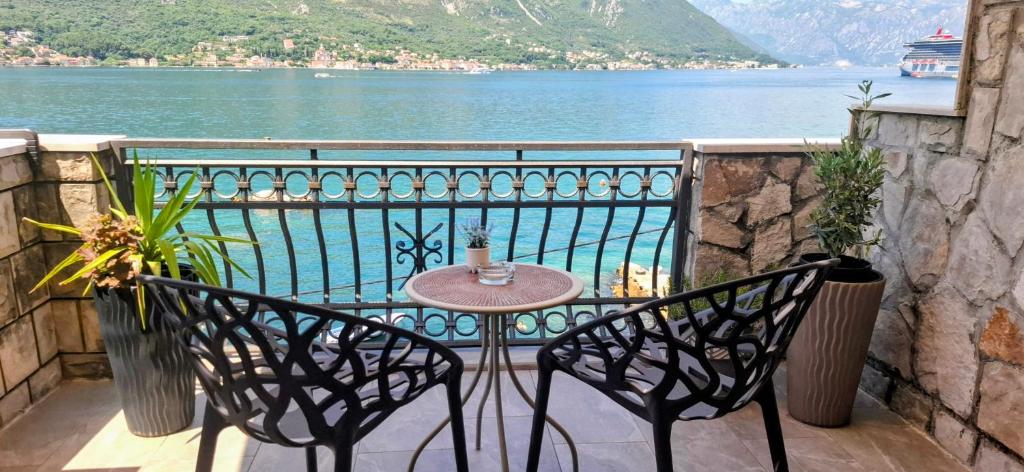 a table and chairs on a balcony overlooking the water at Kadena Apartments in Kotor