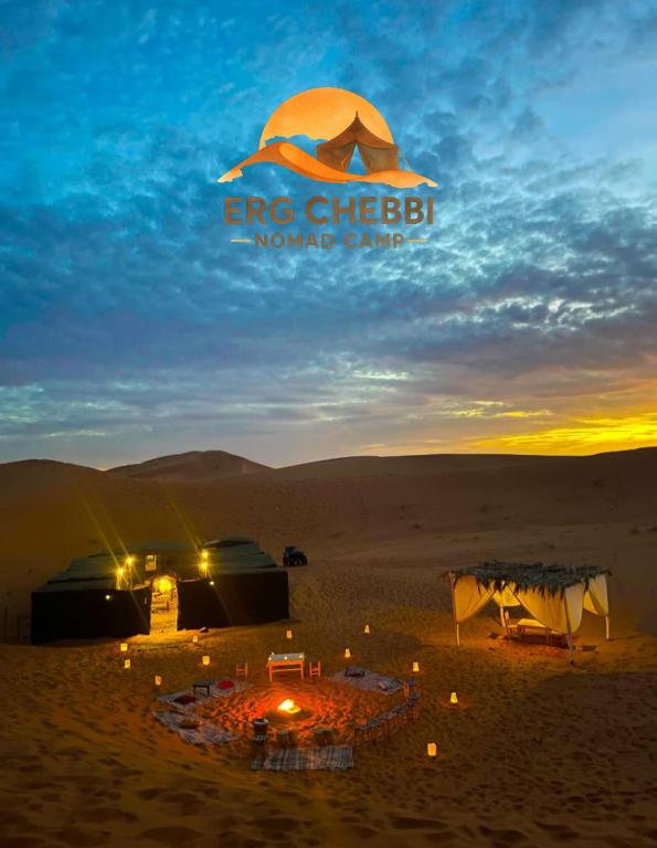 a group of tents in the desert at sunset at Erg Chebbi Nomad Camp in Merzouga