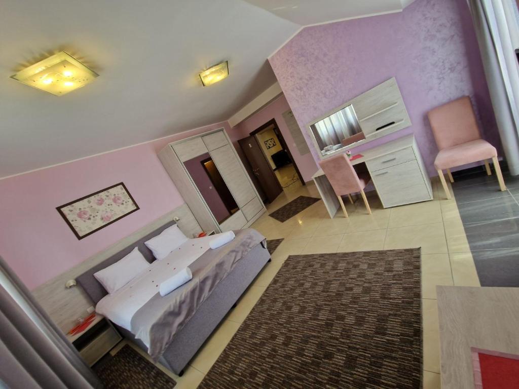 a bedroom with a bed and a pink wall at SOBE Svilajnac in Svilajnac