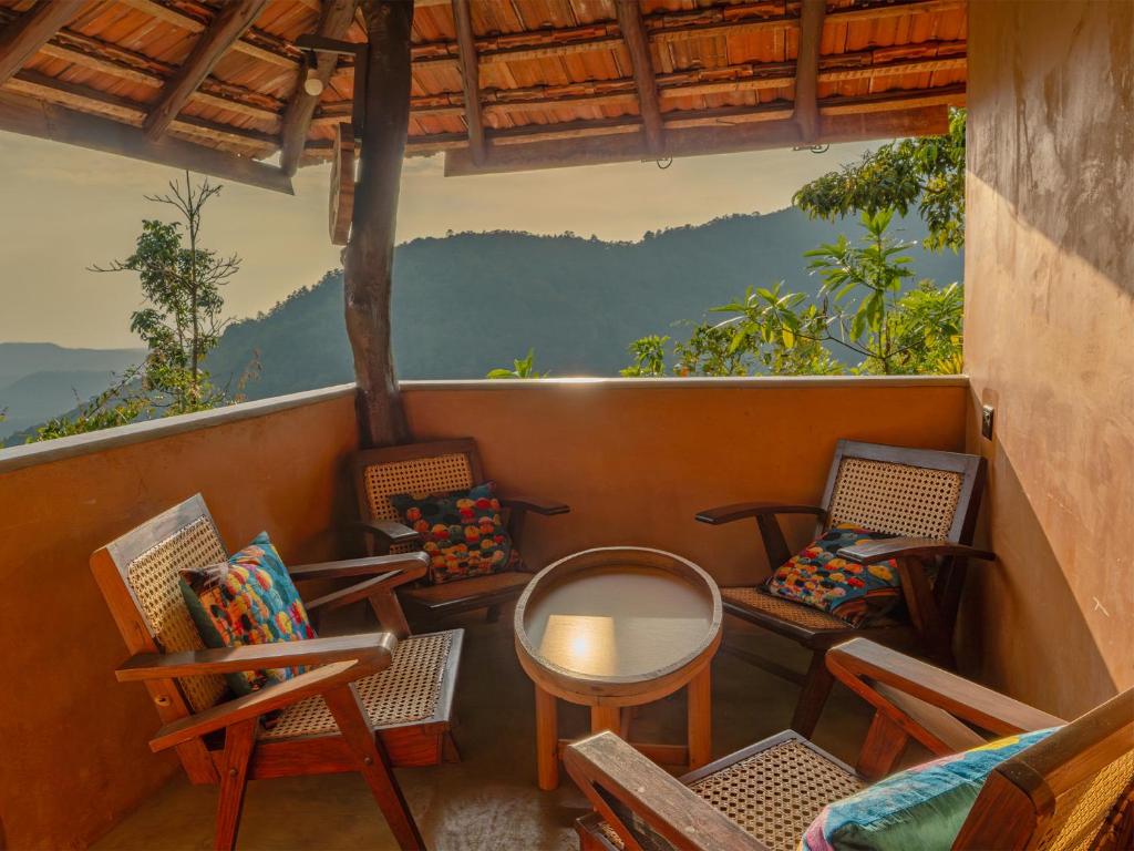 a balcony with chairs and a table and a view at Bathle Eco Resort in Mawanella