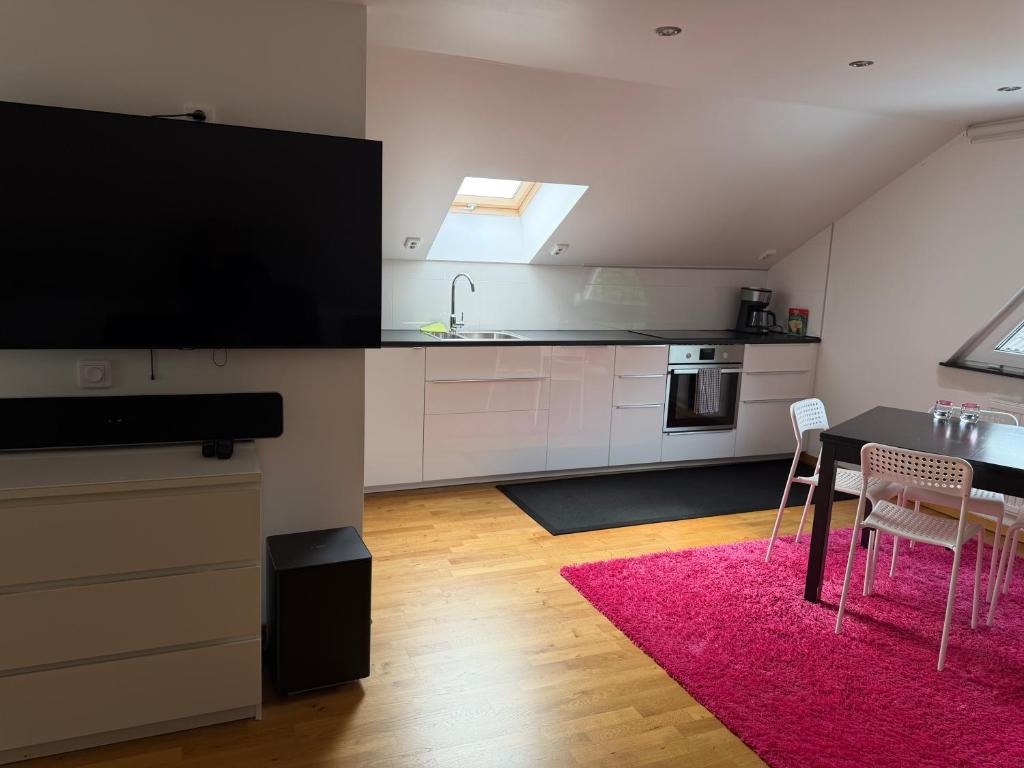 a kitchen with a dining table and a large television at Studio i Nykvarn in Nykvarn
