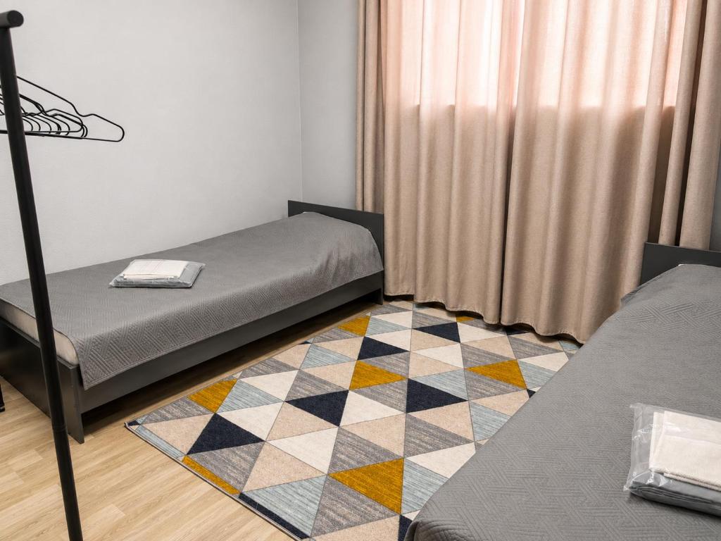 a room with two beds and a checkered floor at Astana Rooms in Astana