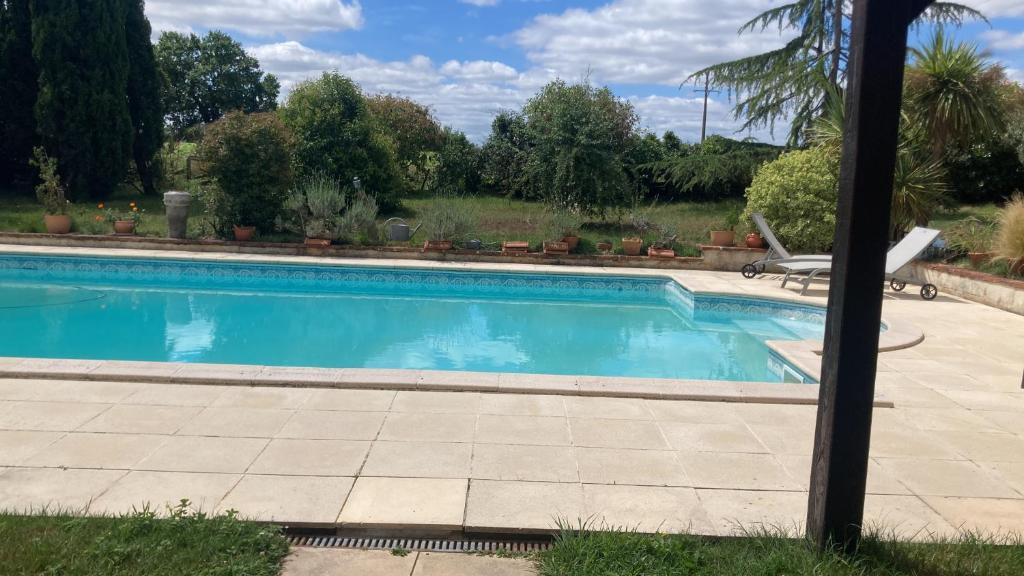 a swimming pool in a yard with a patio at Appartement à colombages indépendant avec piscine partagée avec le proprietaire in Ponsan-Soubiran