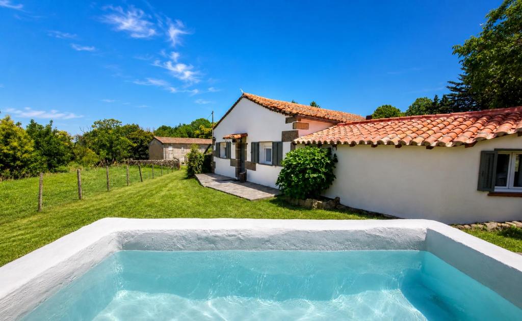 a villa with a swimming pool in front of a house at El cielo de Béjar, casa rural in Béjar