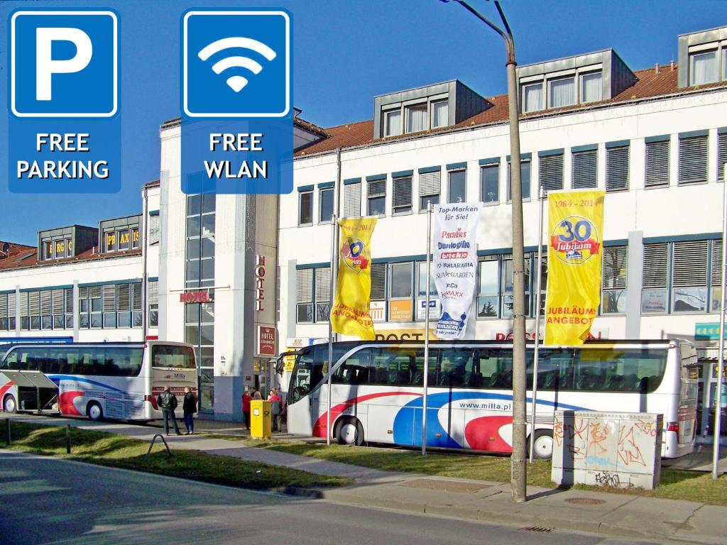 two buses are parked in front of a building at Hotel Amadeus ROYAL Berlin in Berlin