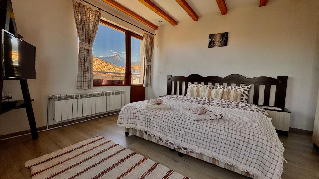 a bedroom with a bed and a large window at Dima Suites Bansko - Vihren view & free parking in Bansko