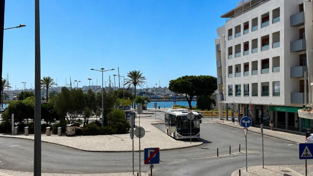 a bus driving down a street next to a building at Portimao riverview T2 luxe 1 floor in Portimão