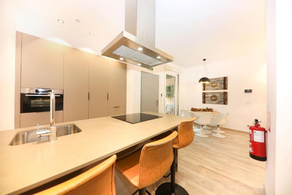 a kitchen with a sink and a counter with chairs at Domus Halo F in Pamplona