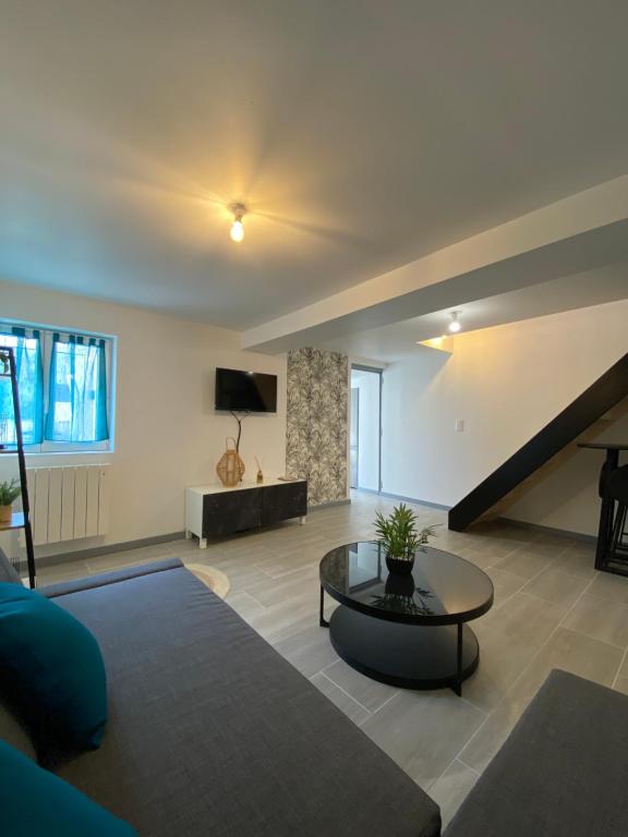 a living room with a couch and a table at Loft cosy 4 in city center in Saint-Benoît-sur-Loire