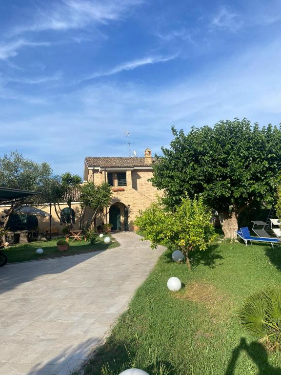 a large house with a yard with a driveway at Un Passo Dal Mare in Lido di Fermo