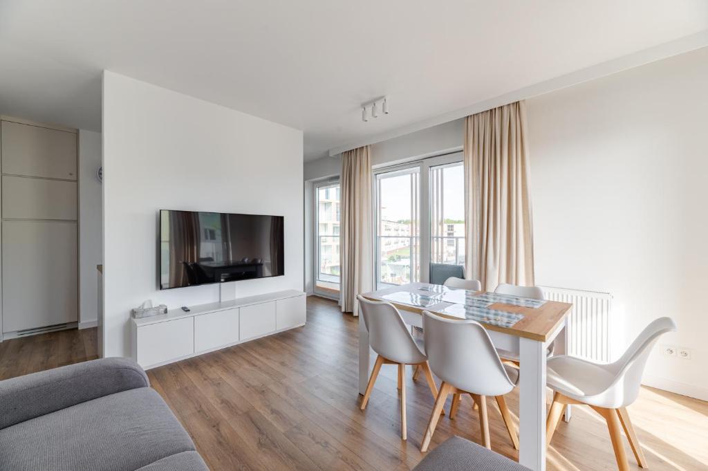 a living room with a table and chairs and a tv at Helskafoka2 in Hel