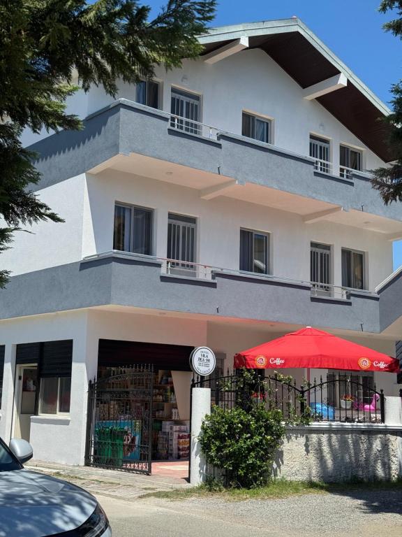 a building with a red umbrella in front of it at Villa DEA in Velipojë