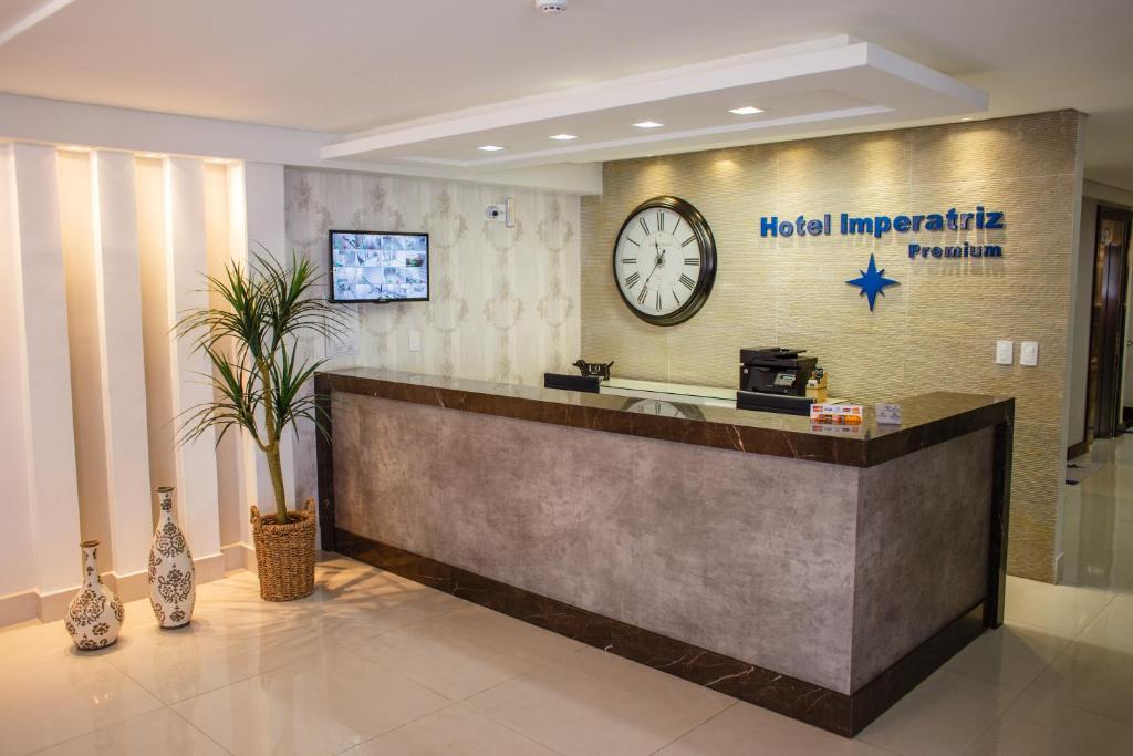 uma sala de emergência do hotel com um relógio na parede em Hotel Imperatriz Premium em Telêmaco Borba