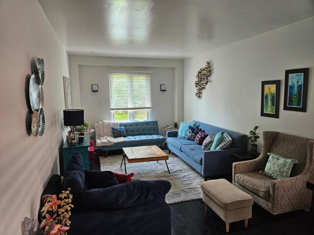 a living room with a blue couch and chairs at Cozy and comfortable home - Living room and Kitchen is shared in Pickering