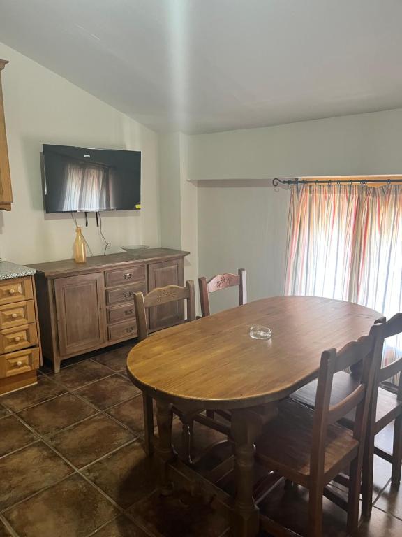a dining room with a wooden table and a tv at Esencia plaza in Hornos