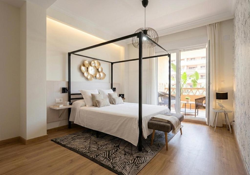 a bedroom with a large bed with a black canopy at Musa apartamentos in El Ejido