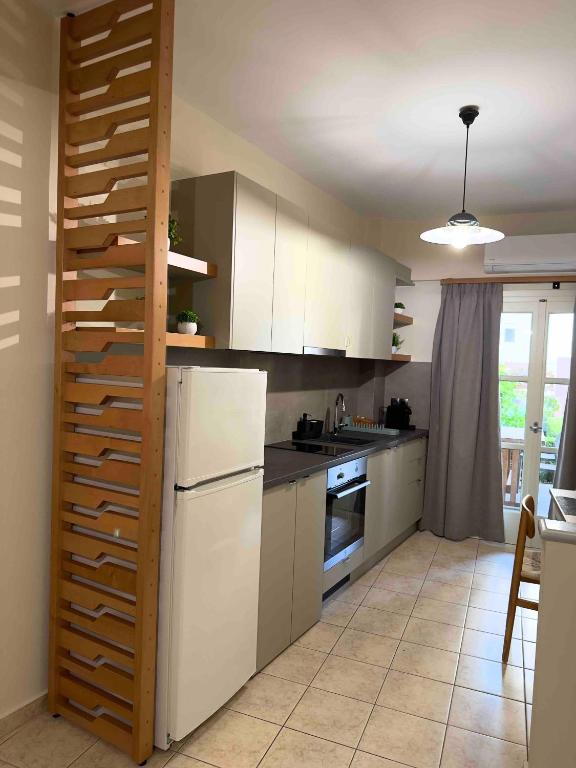 a kitchen with white cabinets and a white refrigerator at Litmus apartment 4 in Karlovasi