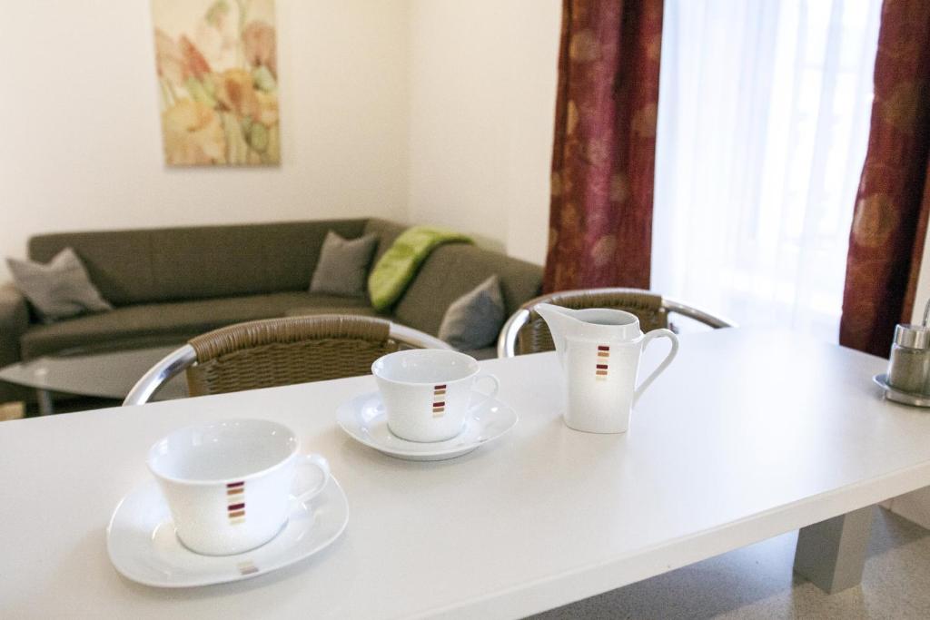 two white cups and saucers on a white table at Riess Apartments Rotenhofgasse | contactless check-in in Vienna