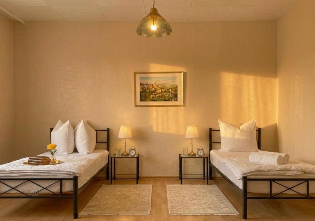 two beds in a room with two tables at Residenz Halberstädter Domschatz beliebt bei Monteuren Einzelbetten WlAN in Halberstadt