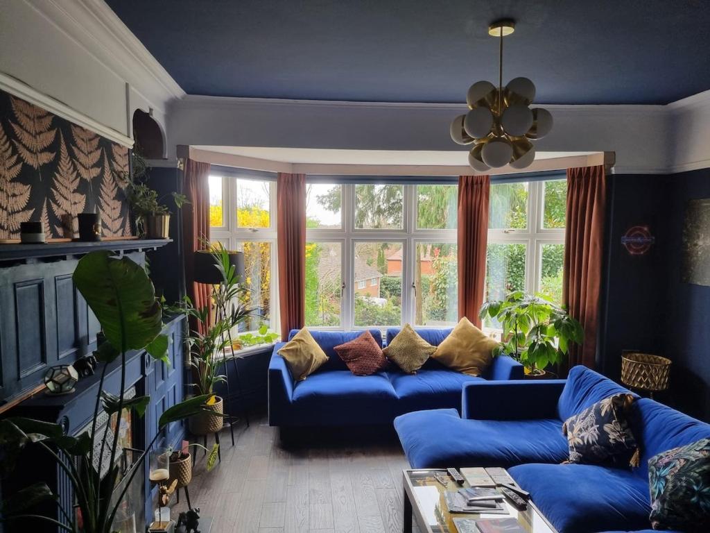 a living room with a blue couch in front of a window at Beautiful ground floor 2 bed flat in Camberley
