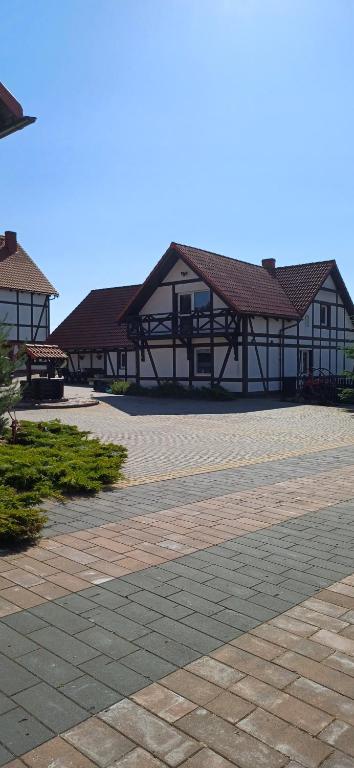 a group of buildings with a patio at Siedlisko na Skarpie in Garcz