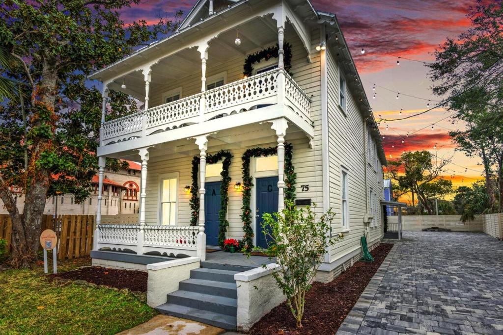 an old white house with a porch and stairs at Cedar Street Retreat - Unit C in St. Augustine