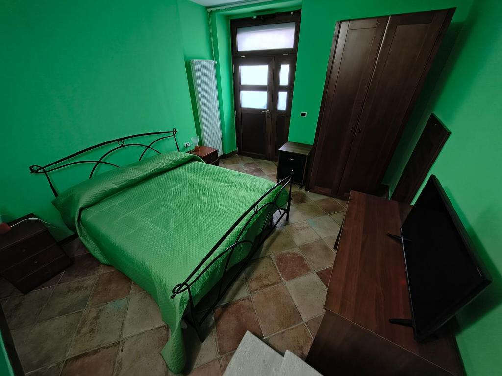 a green bedroom with a bed and a window at Avalon in Pietrelcina
