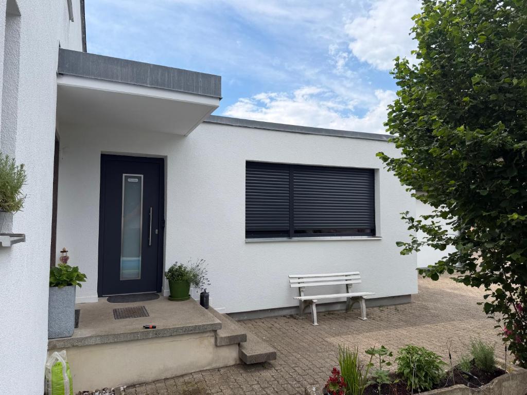 a white house with a bench and a window at Ferienwohnung Am Wasen in Pleinfeld