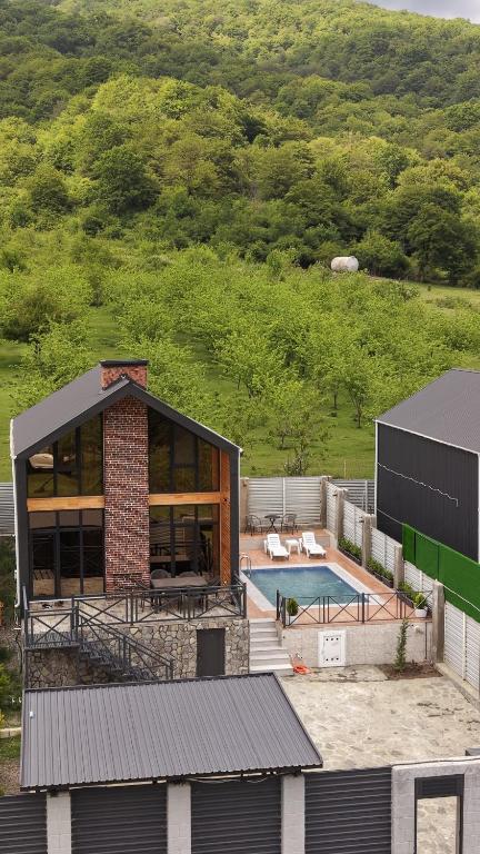 an aerial view of a house with a swimming pool at Pine Barnhouse Family in İsmayıllı