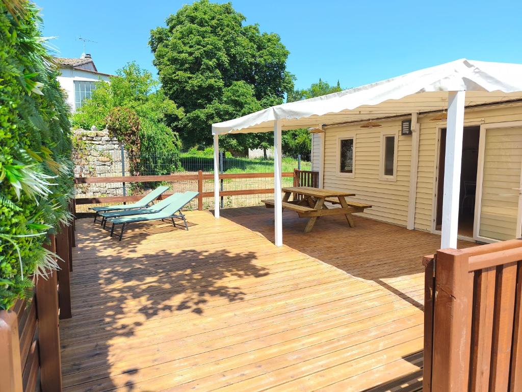 a wooden deck with a picnic table and a pavilion at l'instant provence in Pradons