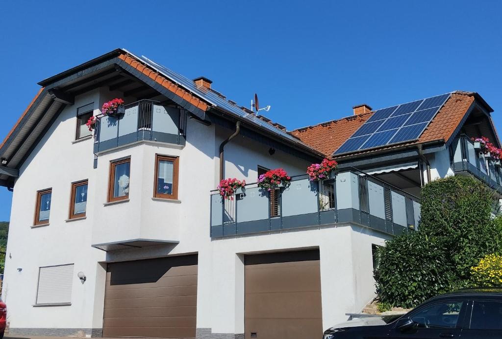 a white house with solar panels on the roof at Gästehaus Klein in Hilders