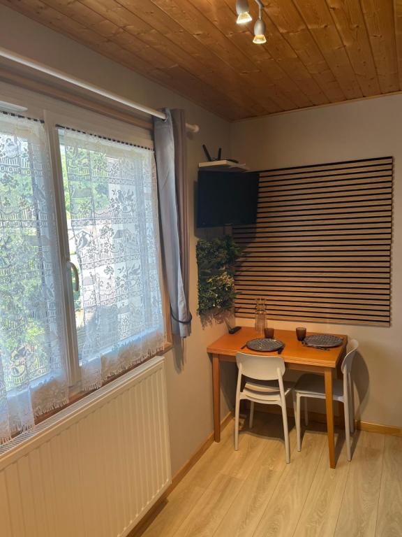 a dining room with a table and two chairs and a window at Le mignon in Pontcharra