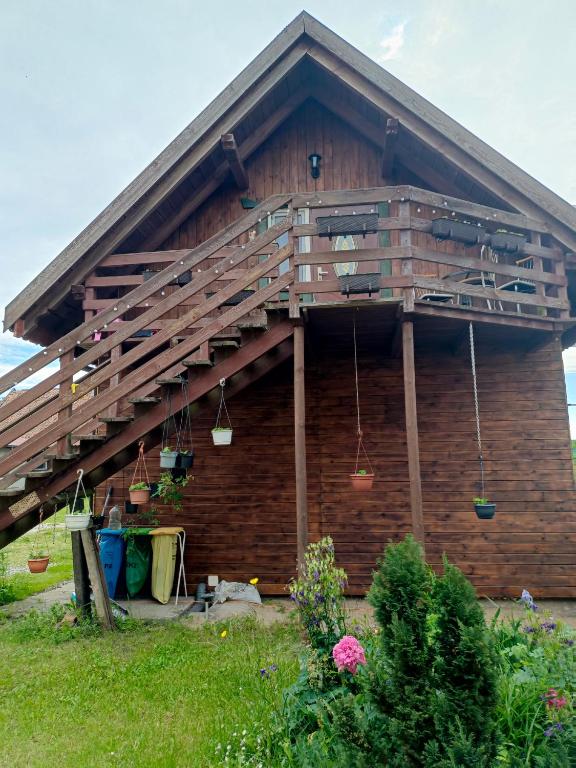 a house with a deck on the side of it at Zacisze pod lasem in Ruciane-Nida