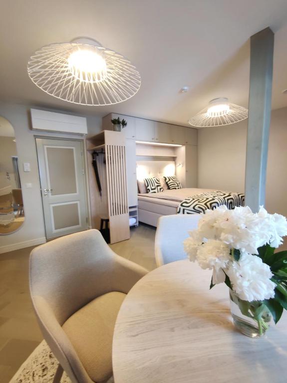 a room with a table with a vase of white flowers at Arte Güldenstubbe Residences in Kuressaare