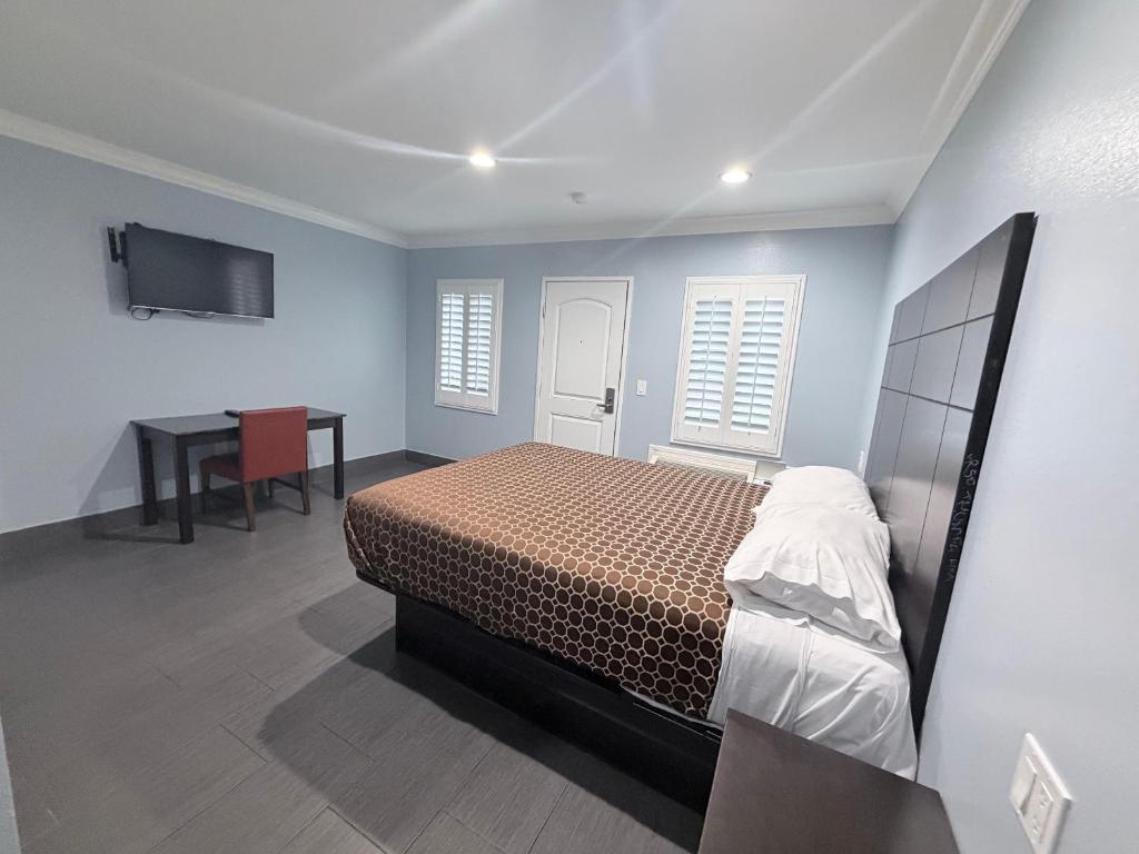 a bedroom with a bed and a desk in it at Coronado Motel in Long Beach