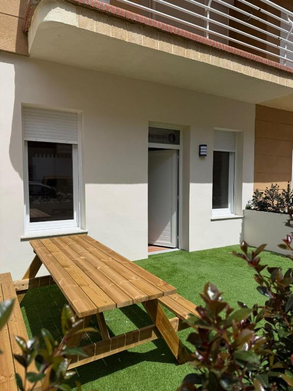ein hölzerner Picknicktisch vor einem Haus in der Unterkunft Hotel Playa de Merón in San Vicente de la Barquera