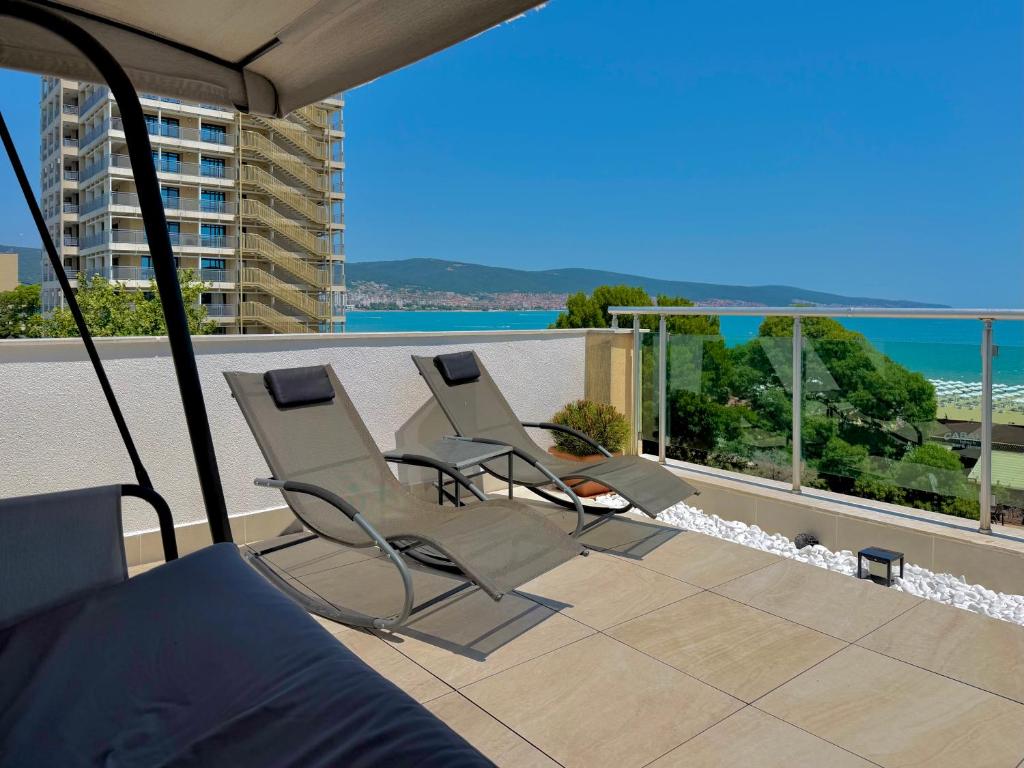 two chairs on a balcony with a view of the ocean at Premium Apartment Midia Beach in Sunny Beach
