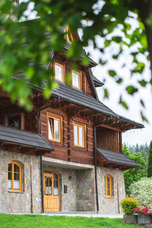 a log cabin building with a stone facade at Willa Rohacze in Kościelisko