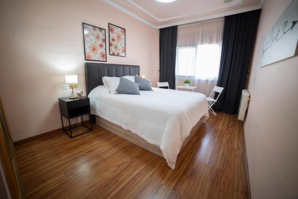 a bedroom with a large white bed and a window at Casa Alcazaba in Guadix
