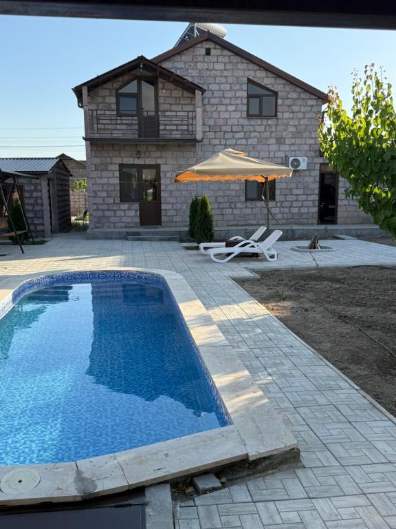 a swimming pool in front of a house at Dreams House in Yengidzha