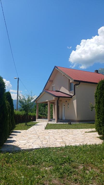 a house with a red roof and a driveway at Vukota - Kuca za odmor in Plav