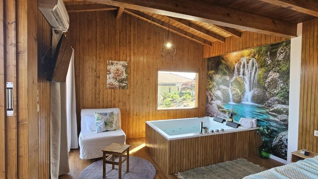 a bathroom with a bath tub with a painting on the wall at Fernandes Guest House Green Bungalow in Ponte de Lima