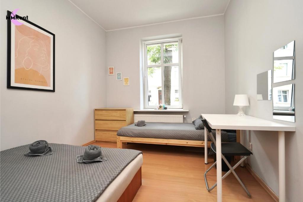 a bedroom with two beds and a desk in it at MMRent Divine Room in Gdańsk