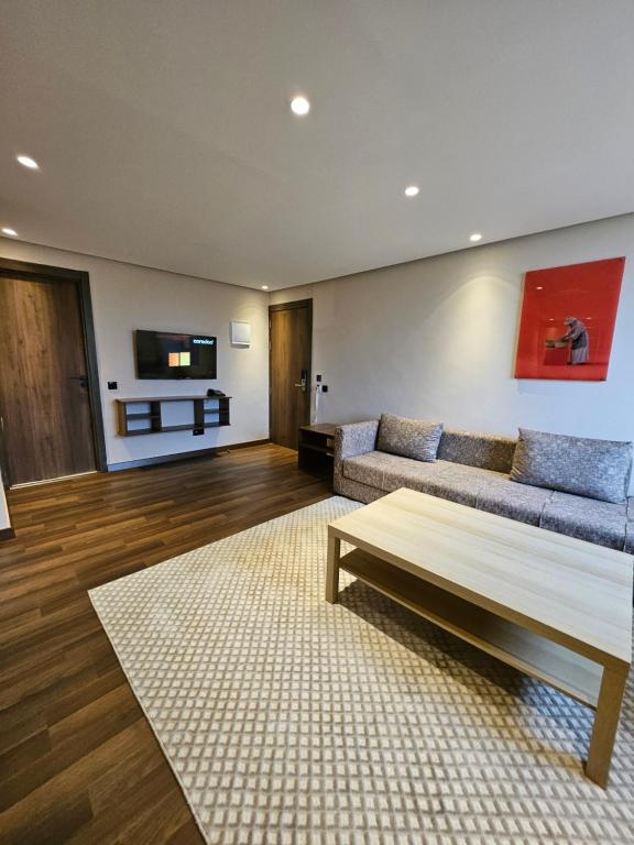 a living room with a couch and a coffee table at Ocean Rooftop Hotel in Ben Slimane