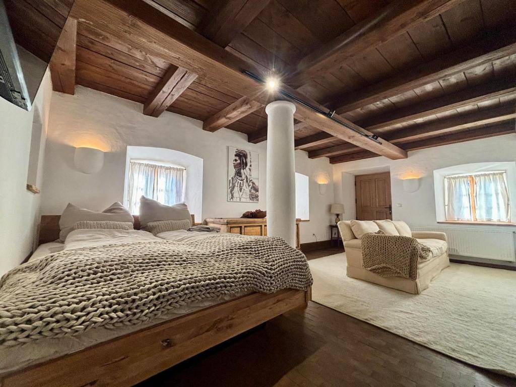 a large bedroom with a large bed and a couch at Stallrefugium - between lakes, mountains and silence in Seeon-Seebruck